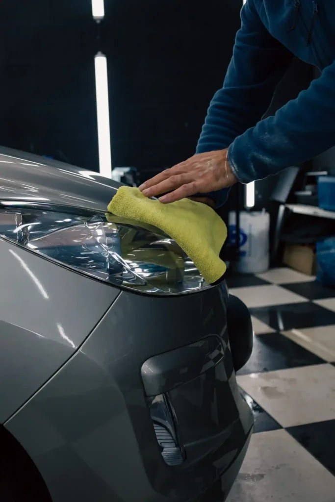 nettoyage d'un phare dans un atelier automobile avec un chiffon