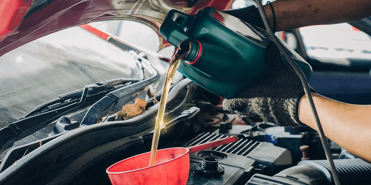Un mécanicien fait une vidange sur un véhicule
