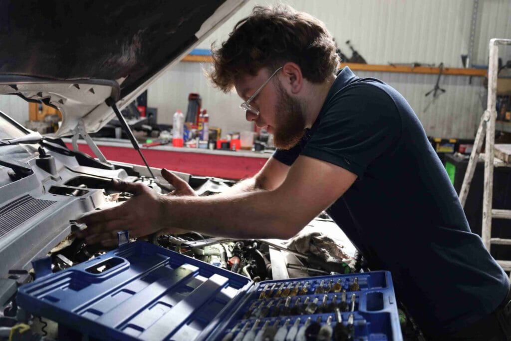 mécanicien qui répare le moteur d'une voiture